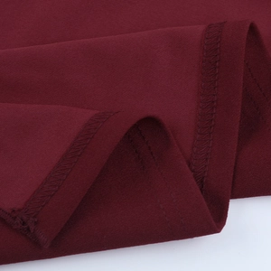 Macro shot of burgundy sparkling fabric texture with fine double-needle stitching details