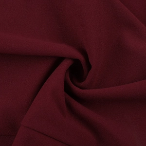 Macro shot of dark red shimmer fabric showing fine texture and smooth drape of the dress