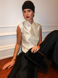 Close-up of champagne satin sleeveless top with mandarin collar and side buttons