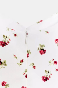 Dettaglio dell'abito floreale a rose con cerniera bianca invisibile sulla schiena