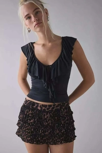 Dettaglio del gilet nero con scollo a V e balze e minigonna a balze stampa leopardata