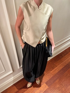 Detail of champagne gold satin sleeveless top with traditional frog buttons and high collar