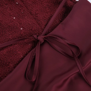 Close-up of burgundy tweed with sequins and satin fabric bow on a slim dress