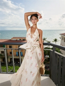 Elegant floral halter backless maxi dress with waist ruffles and matching straw bag