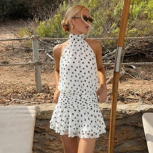 Detailed view of backless polka dot mini dress with waist pleats and ruffle hemline