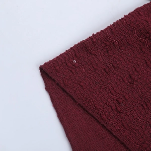 Detail of wine red textured tweed fabric with subtle sequins for cocktail dress