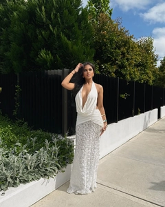 Detail of white halter neck dress with deep V-neck and 3D textured rose flower skirt