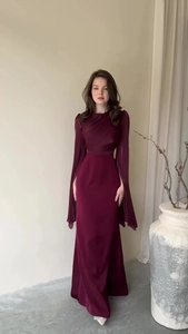 Detailed view of burgundy evening gown with pleated bodice and split cape sleeves