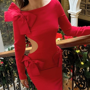 Détail de la robe rouge moulante avec découpe latérale et gros nœud décoratif