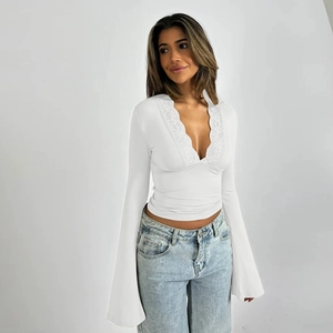 Elegant white long sleeve top featuring deep V-neck lace trim and wide bell sleeves