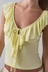 Top aderente giallo pallido a maniche lunghe con scollo a V a volant e lacci decorativi