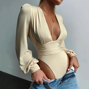 Detailaufnahme von tiefem V-Ausschnitt und geraffter Textur am cremefarbenen Body