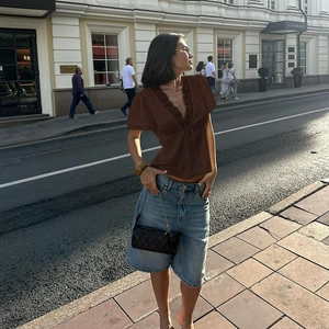 Dettaglio del top con scollo a V con bordo in pizzo e coulisse su tessuto marrone