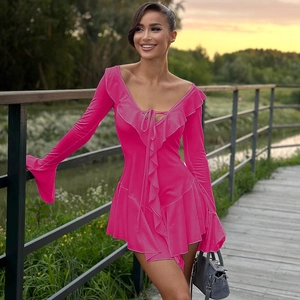 Dettaglio dell'abito corto fucsia con bordi a balze e scollatura a V stringata