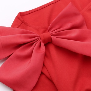 Gros plan sur un grand nœud rouge d'une robe de soirée dos nu pour les festivités