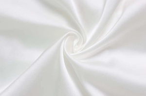 Dettaglio del tessuto in raso bianco setoso con elegante drappeggio e lucentezza