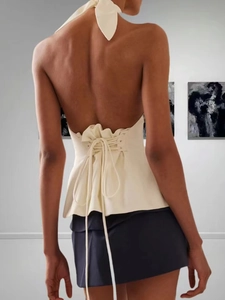 Chic backless halter top with corset-style lace-up detail and ruffled hem in cream