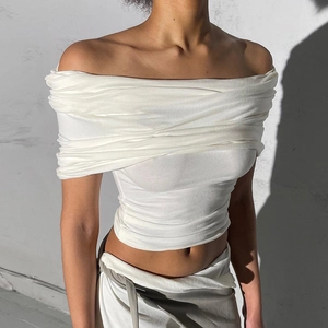 Détail du haut court blanc à épaules dénudées avec texture plissée et finitions soignées