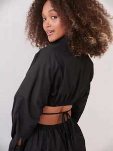 Abito a camicia corto nero con schiena scoperta, maniche a sbuffo e lacci sul retro