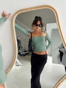 Mirror reflection showing details of women's slim fit green tube top with long sleeves