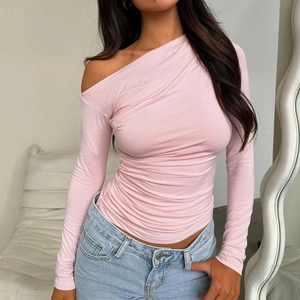 Détail du haut rose clair à manches longues dénudé avec texture froncée et coupe ajustée