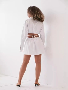 Vista posteriore abito a camicia in cotone bianco traforato con maniche a lanterna e lacci
