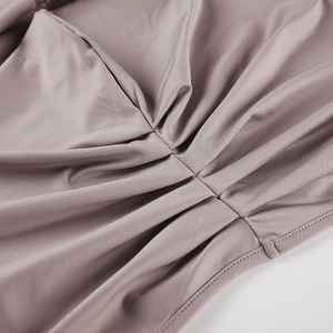 Détail du tissu froncé rose poudré avec une texture lisse et des coutures fines