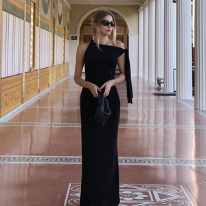 Détail d'une élégante robe longue noire à une épaule avec ruban décoratif à l'épaule