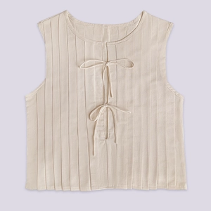 Detail of elegant beige linen vest with pleated texture and stylish front tie-up design