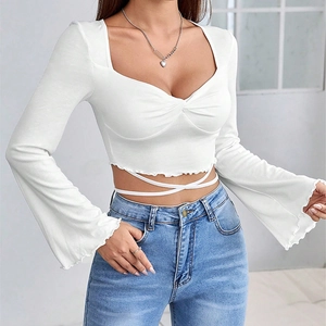 Detailed view of flared sleeves and waist tie-up strings on white elegant crop top