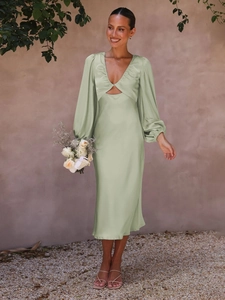 Detail of sage green satin dress featuring deep V-neck and cut-out lantern sleeves