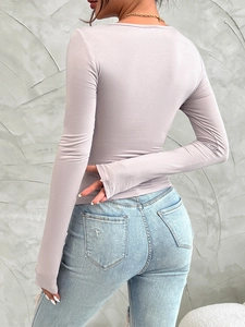 Detail of lavender slim-fit long-sleeve top paired with faded blue denim jeans
