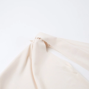 Gros plan du détail noué élégant sur une robe moulante beige pour l'automne