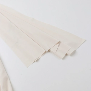 Vue détaillée du tissu en mousseline crème superposé avec des plis et une texture douce