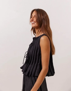 Side view of elegant black pleated sleeveless top with side lace-up tie details