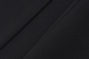 Dettaglio macro di tessuto twill nero con cuciture di precisione per abito aderente