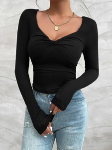 Close-up of the elegant twist knot detail and V-neckline on the black slim-fit top