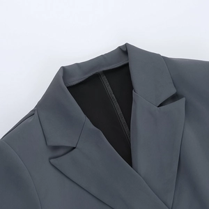 Detail of dark grey blazer collar showing professional lapel stitching and black lining