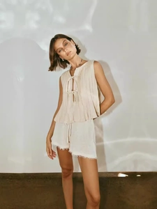 Elegant sleeveless pleated linen set with tie-up vest and raw hem shorts in beige