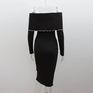 Detail showing the white ruffled hem and black ribbed knit texture on back of dress