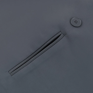 Close-up of a well-crafted welt pocket and round button on a dark grey blazer jacket