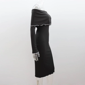Detail of black off-shoulder ribbed dress featuring elegant white ruffled hem edges