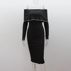 Detail of black ribbed knit dress featuring elegant white ruffled trim on the neckline