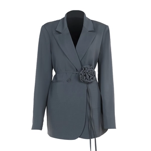 Detail of grey-blue slim fit blazer with large fabric flower and thin waist belt
