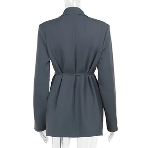 Detail view of dark grey blazer showing waist tie belt and pleated hemline on back
