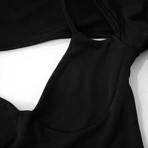 Macro detail showing the fine knit texture and precise stitching of the black dress fabric