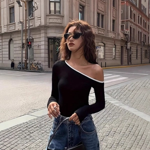 Detail of slim fit long sleeve top with asymmetric off-shoulder design and white piping