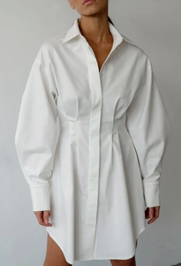Détail d'une robe chemise blanche avec col à revers structuré et taille plissée