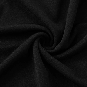 Detailed close-up of premium black knit fabric texture showing fine stitching and soft drape
