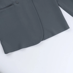 Detailed close-up of charcoal grey blazer hem with precision stitching and flat welt pocket